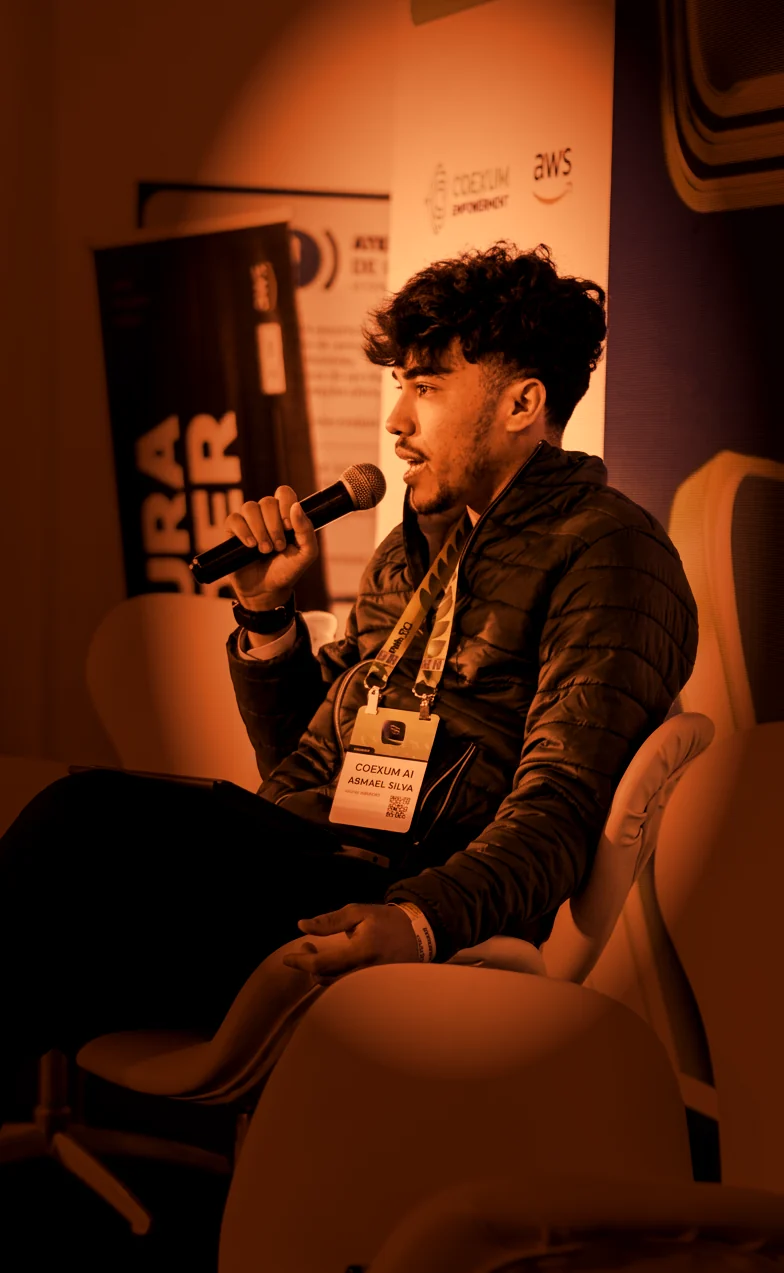 Abimael Silva falando ao microfone em um painel no Blockchain.RIO