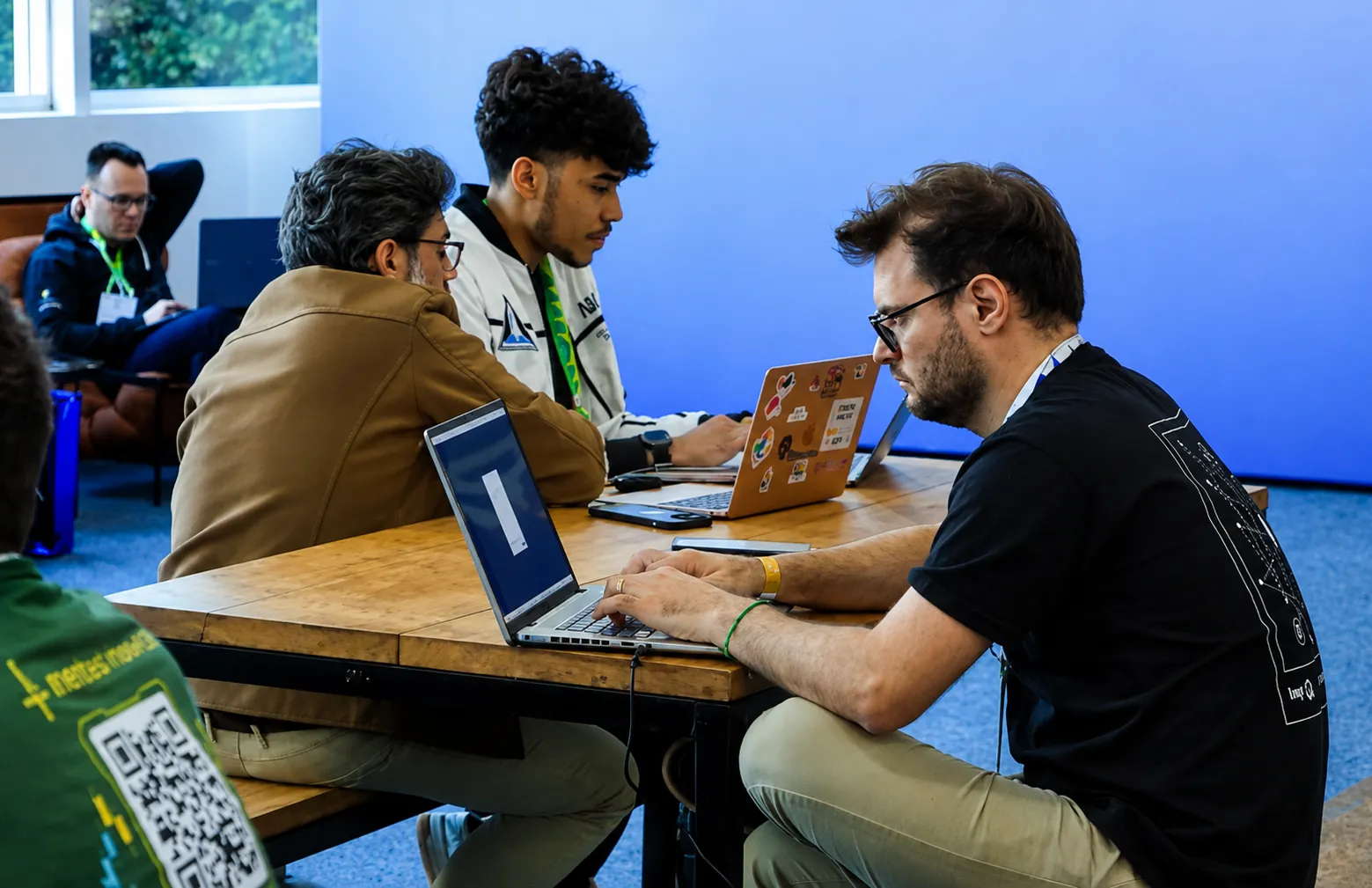 Abimael trabalhando no notebook em uma mesa do evento